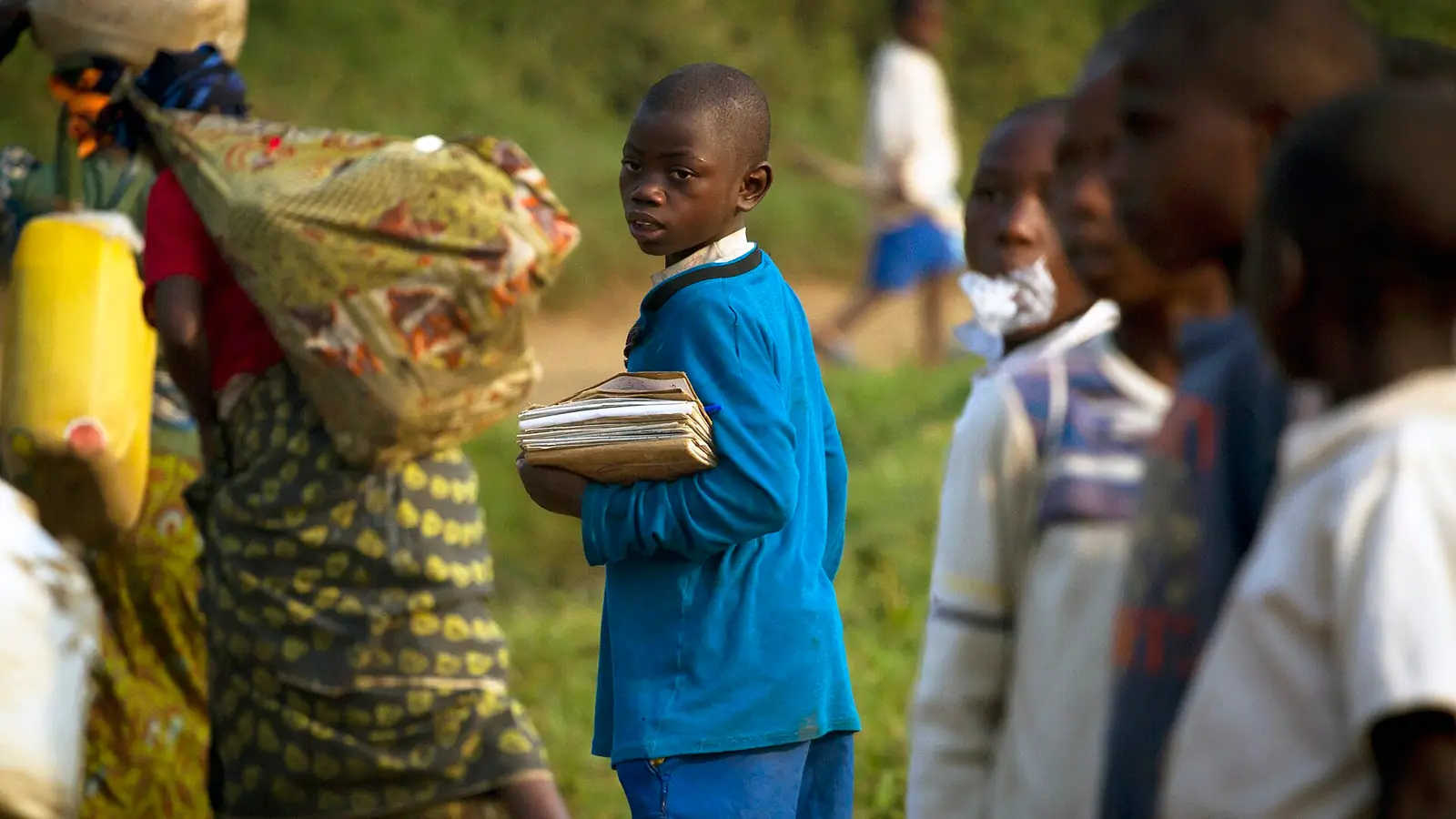 A young Congolese boy walking to school near a refugee camp